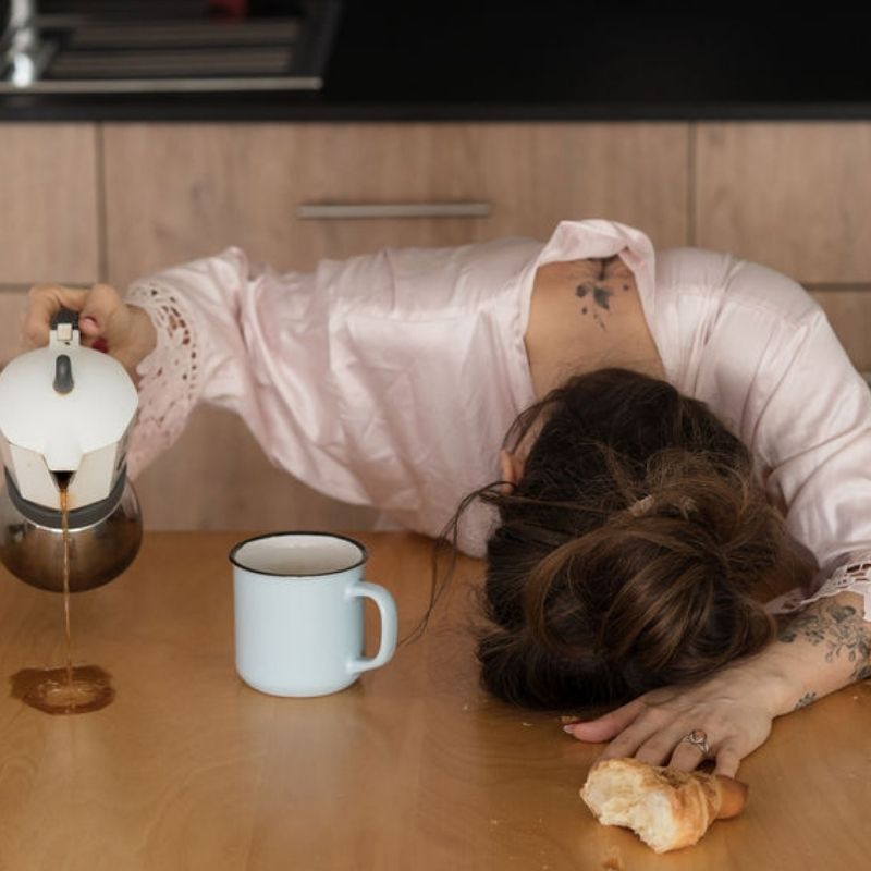 femme épuisée cafe table